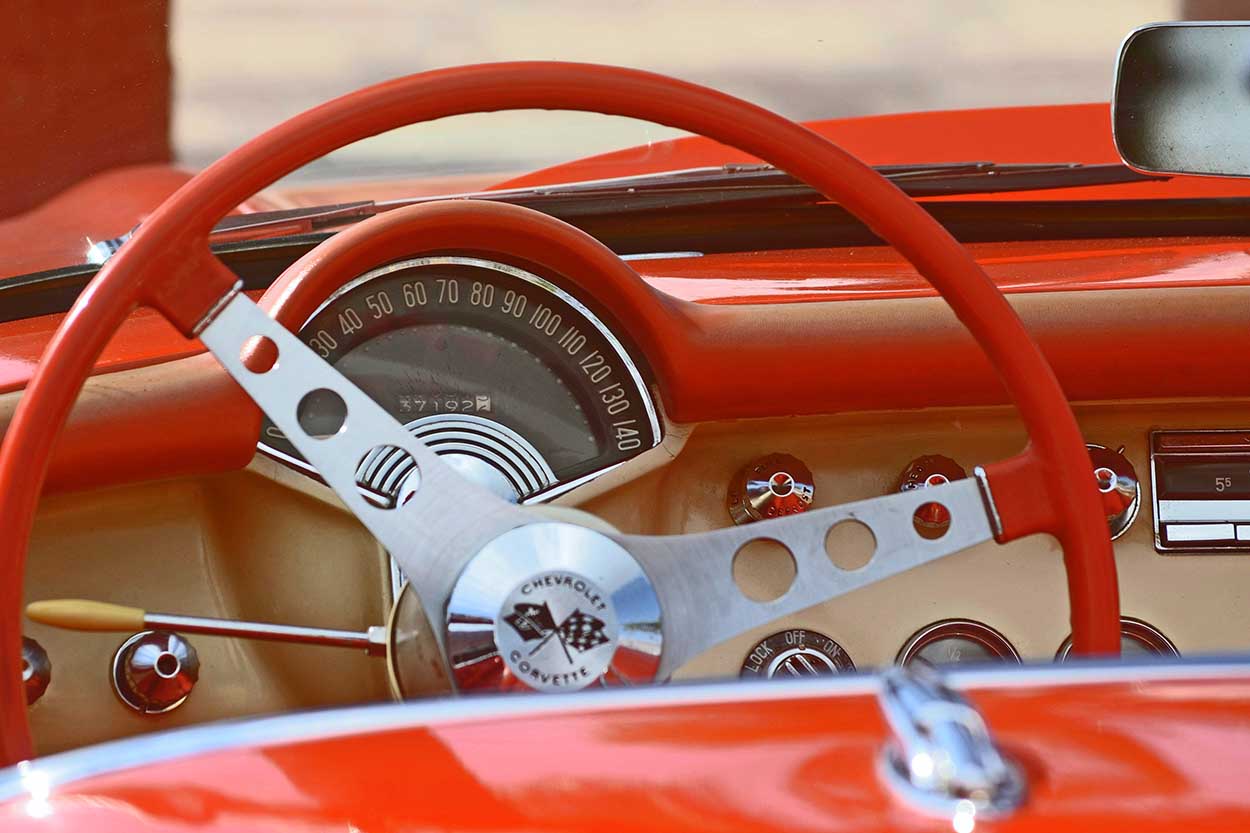 Oldtimer Autopflegeprodukte Roter Oldtimer Cockpit mit beigen Highlights und Metall-Lenkrad